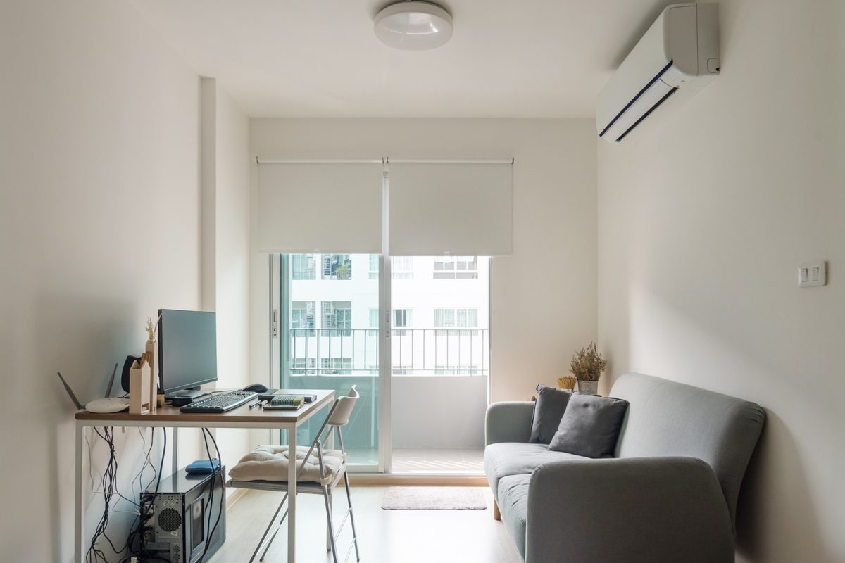 Sala de apartamento com ar-condicionado ligado e porta aberta para varanda