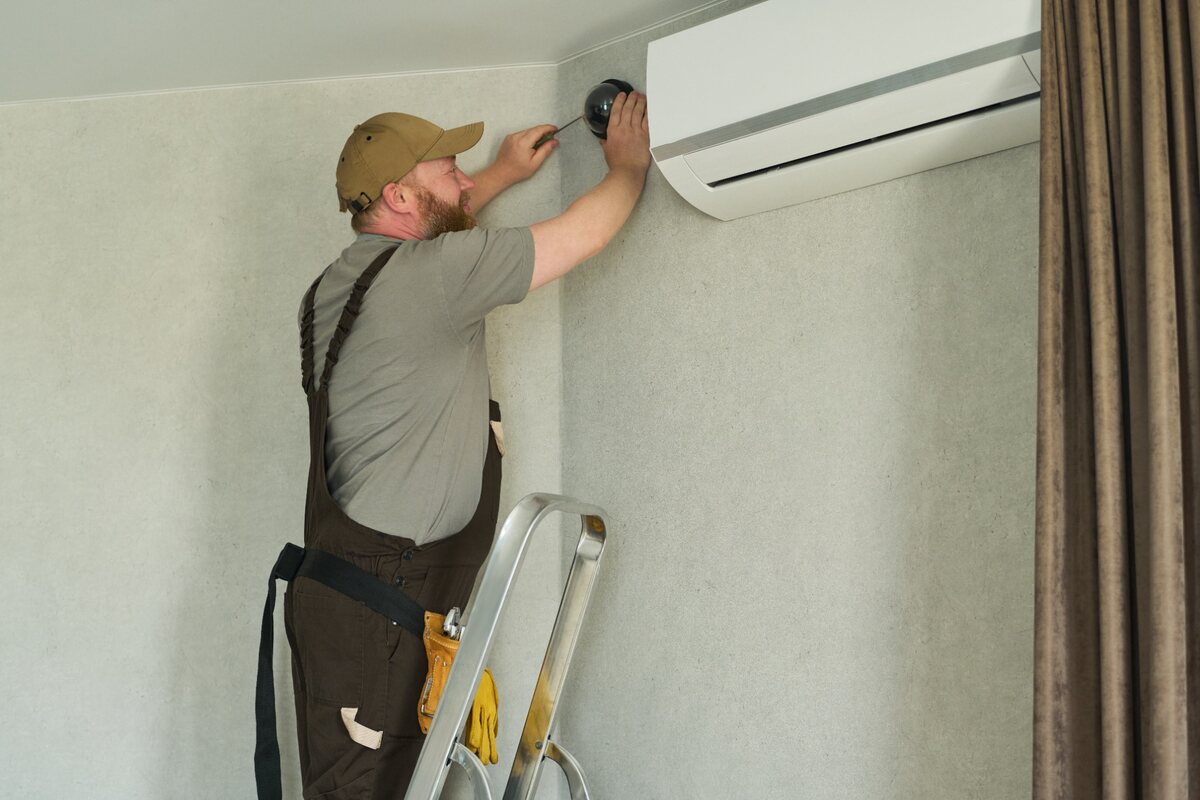 Técnico realizando a instalação de um ar-condicionado split em uma residência.